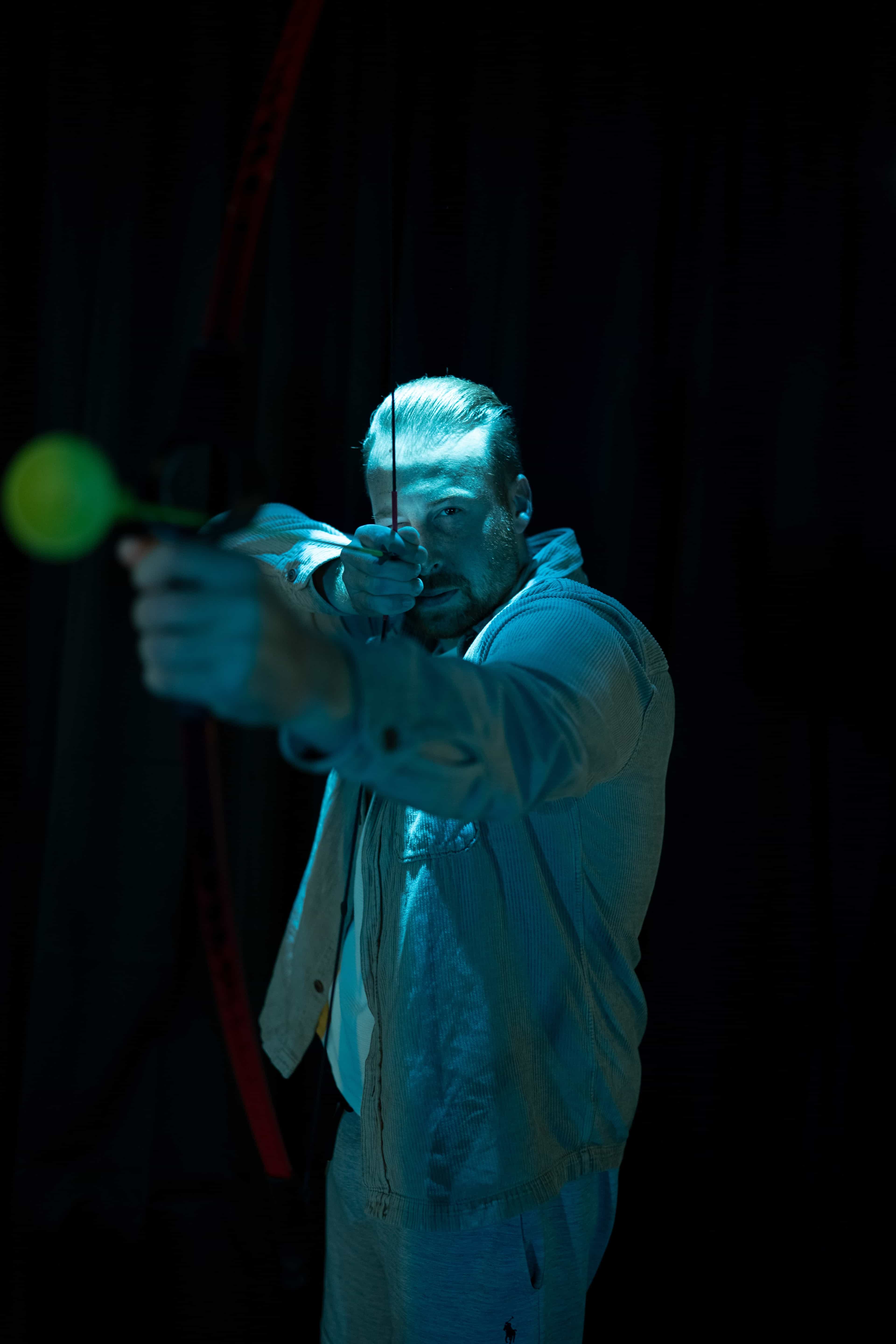 Teilnehmer zielt mit Pfeil und Bogen